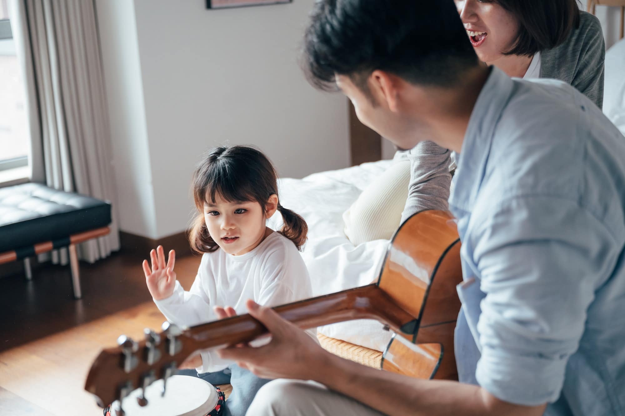 Happy family playing instruments in bedroom